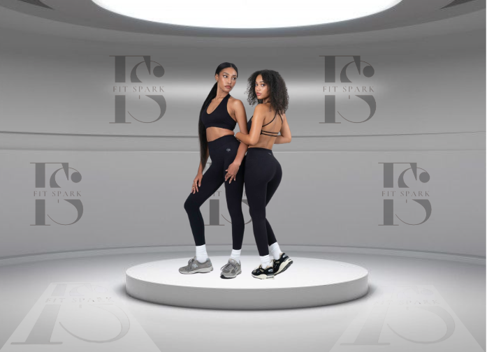 Deux mannequins portant des brassières de sport FITSPARK noires, posant sur un podium circulaire blanc dans un décor moderne et épuré